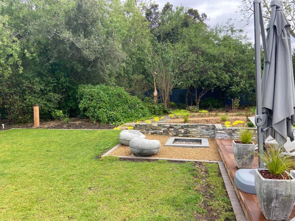 Outdoor living area framed by planting